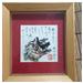 Origami lady in kimono, with cursive style calligraphy in a wooden frame. 

I have no idea what the calligraphy says though.